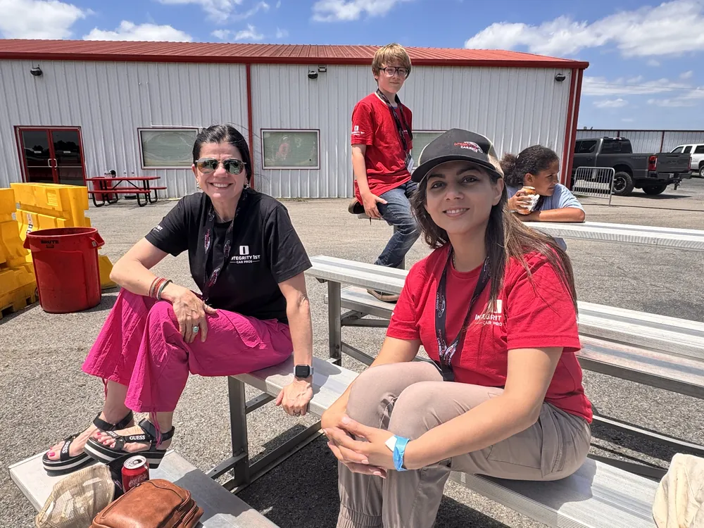 Integrity 1st team members watching from the stands at the team race event